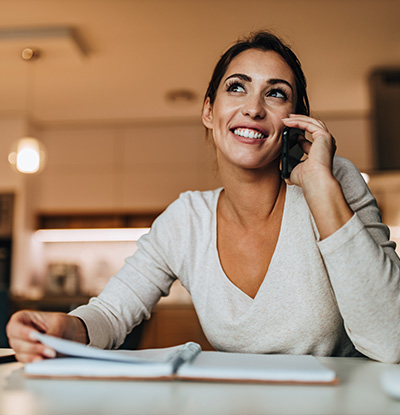 The image shows two photographs of a woman engaged in phone conversations  in the left image, she s smiling and holding a pen, while in the right image, she appears more focused with her hand on her chin.