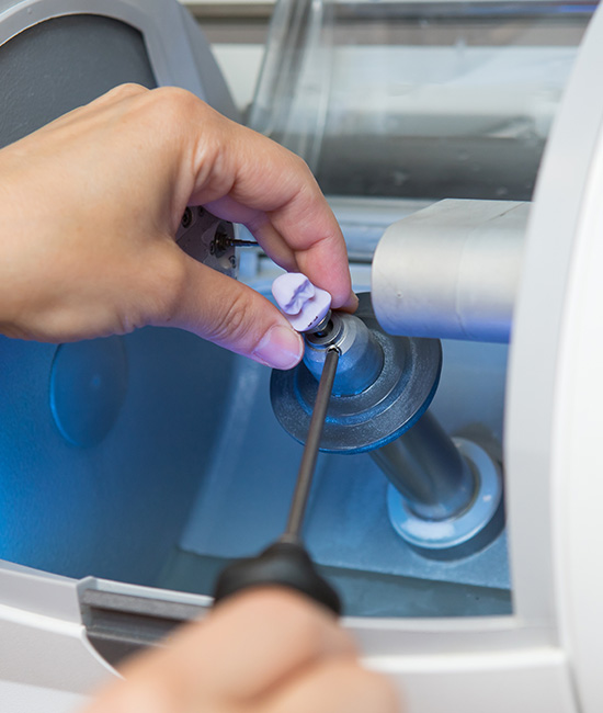 A person s hand holding a small object over a blue light, possibly for inspection or examination.