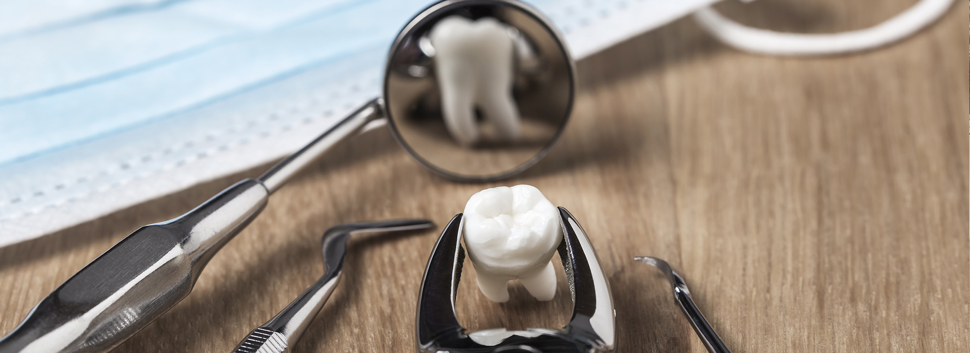 A close-up photograph of a transparent marble resting on top of a pair of scissors with black handles.