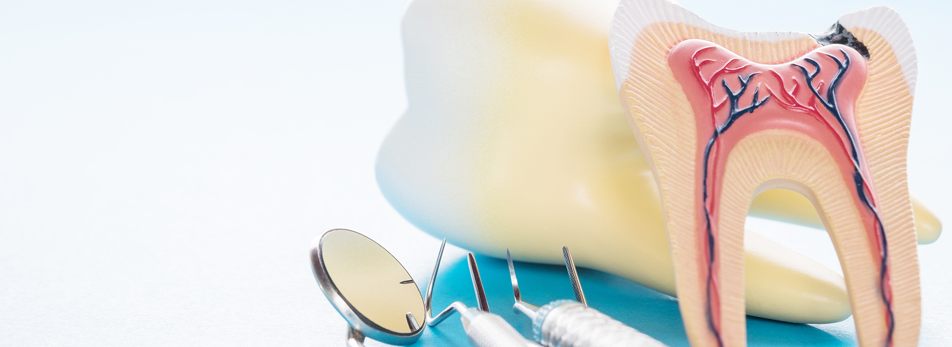 The image shows a pair of yellow flip-flops with a toothbrush placed on top, set against a blurred background.