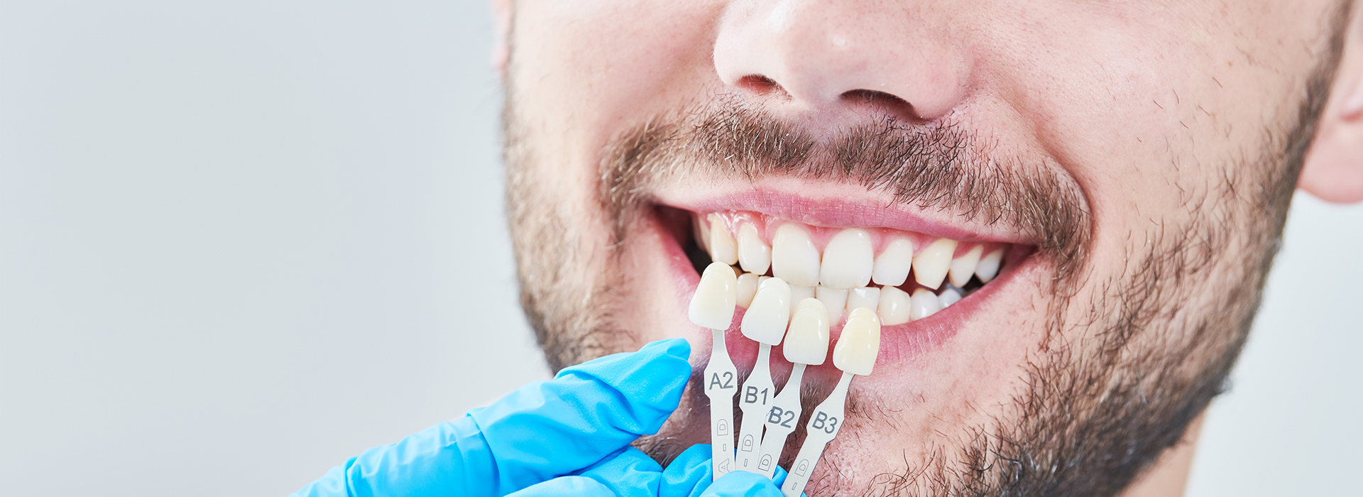 The image displays a person wearing a surgical mask with a mouthful of dental floss, holding a toothbrush near their teeth, and smiling at the camera.